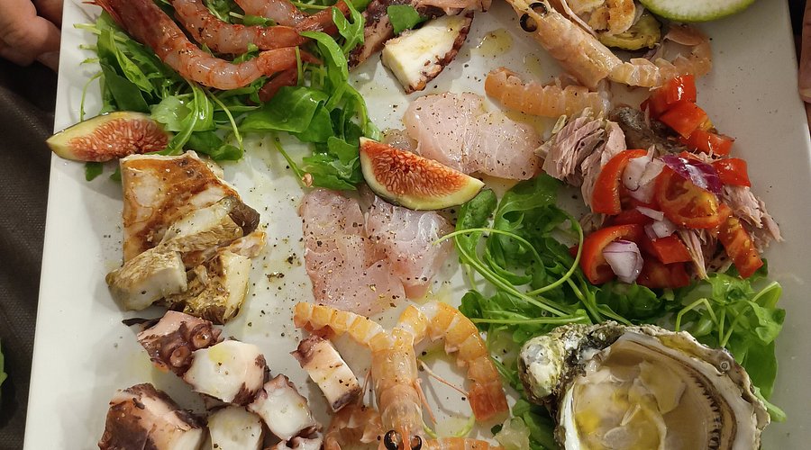 Piatto di mare con gamberi crudi, polpo grigliato, ostrica, tonno, fichi e rucola della Trattoria Da Zia Lina